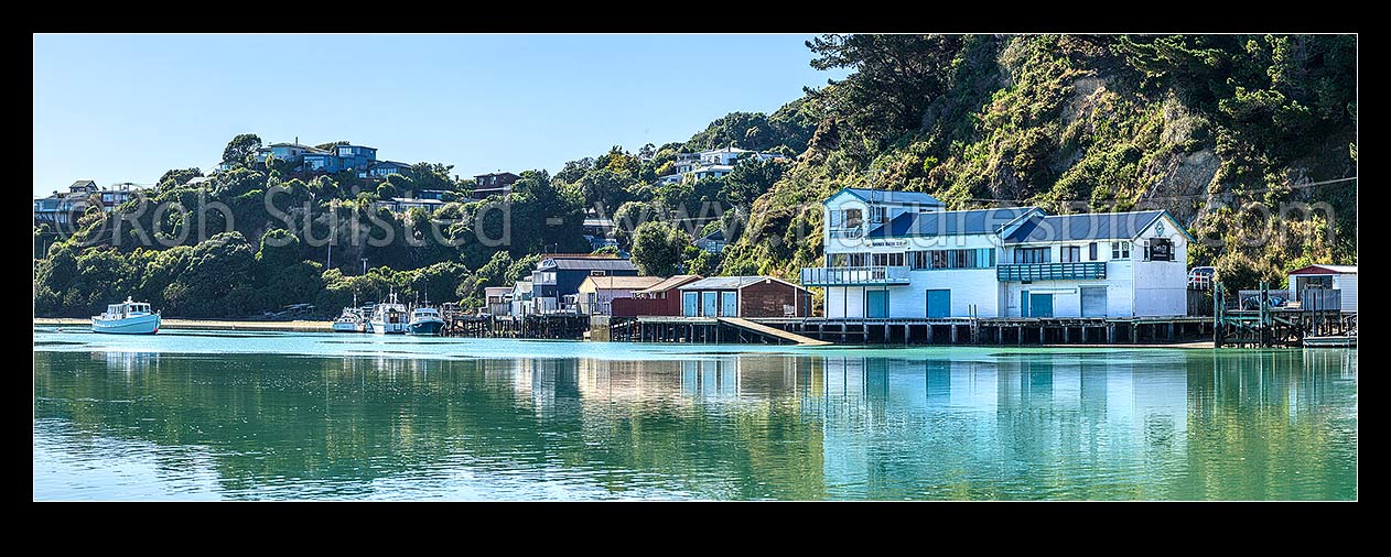 Image of Paremata boatsheds and boating club reflected at Ivey Bay on the Pauatahanui Inlet arm of Porirua Harbour. Panorama, Paremata, Porirua City District, Wellington Region, New Zealand (NZ) stock photo image