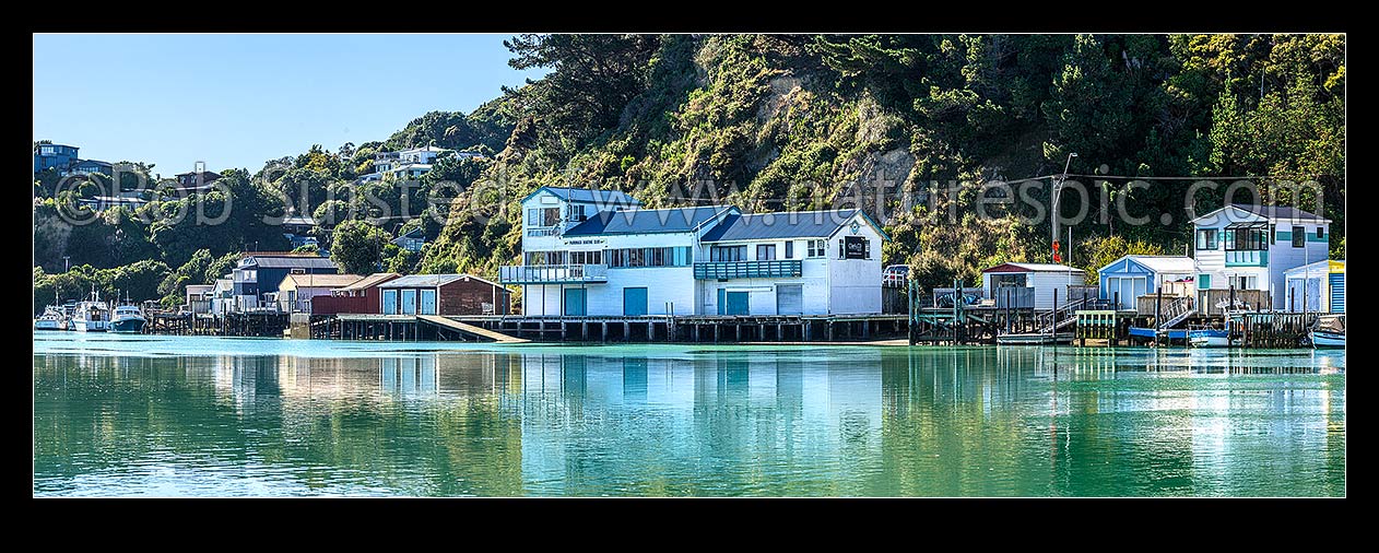 Image of Paremata boatsheds and boating club reflected at Ivey Bay on the Pauatahanui Inlet arm of Porirua Harbour. Panorama, Paremata, Porirua City District, Wellington Region, New Zealand (NZ) stock photo image