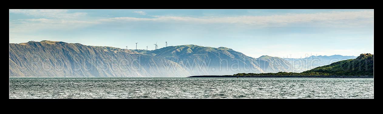 Image of Porirua west coast, looking past Shingle Point Mana Island and 'The Bridge' towards Pipinui Point and Makara. Mill Creek and West Wind wind farms. Panorama, Titahi Bay, Porirua City District, Wellington Region, New Zealand (NZ) stock photo image