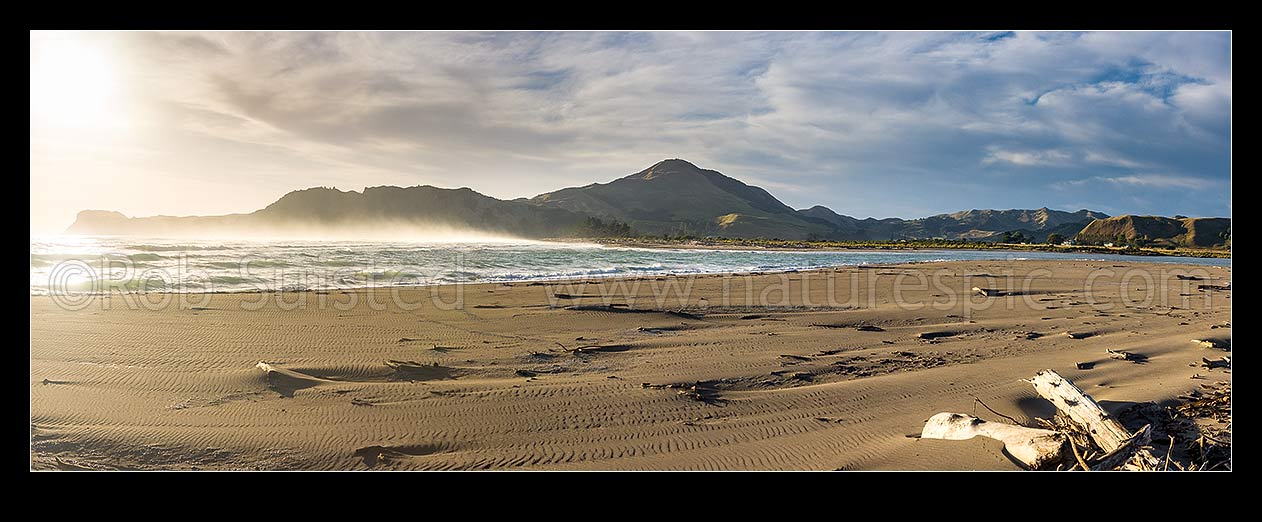 Image of Tolaga Bay beach on a cool summer morning, with mist on water. Uawa River mouth. Titirangi Hill (343m) centre. Panorama, Tolaga Bay, Gisborne District, Gisborne Region, New Zealand (NZ) stock photo image