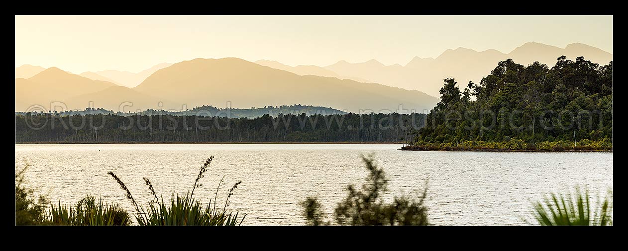 Image of Lake Mahinapua Scenic Reserve panorama at dawn, looking past Hobart Point and Picnic Bay to Mt Graham (829m) centre left and Southern Alps Main Divide in distance, Hokitika, Westland District, West Coast Region, New Zealand (NZ) stock photo image