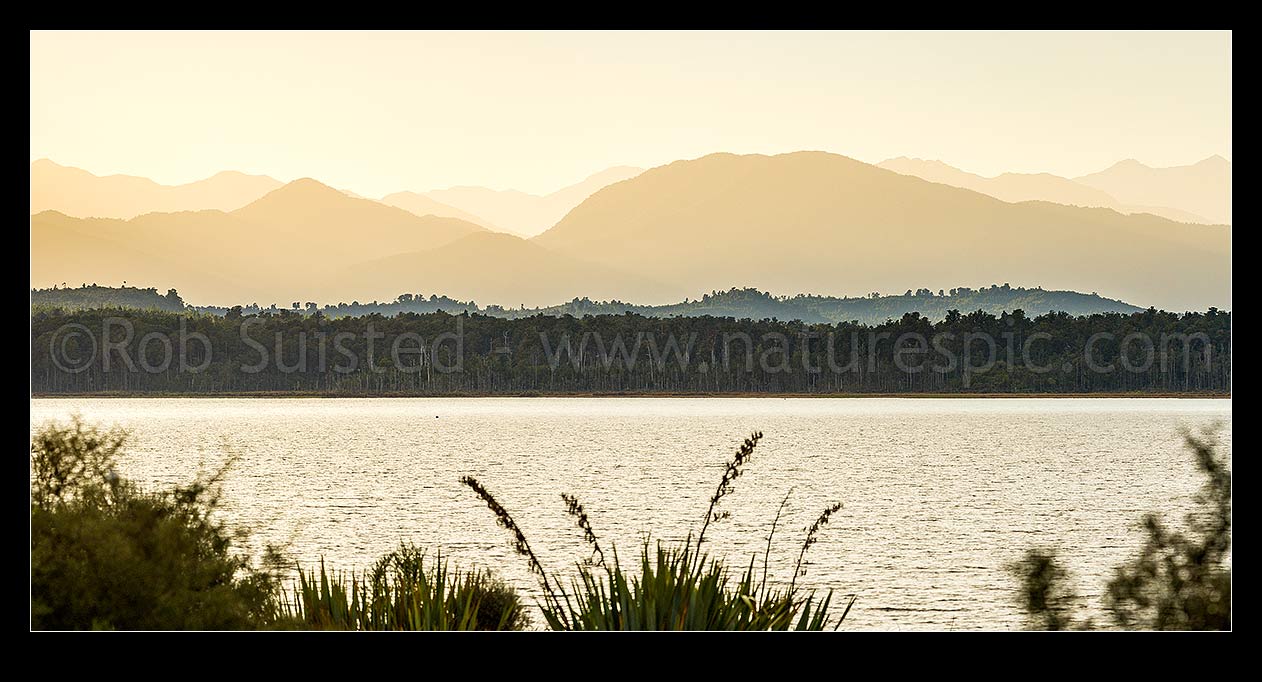 Image of Lake Mahinapua Scenic Reserve panorama, looking over Picnic Bay to Mt Tuhua (1125m) left, Mt Graham (829m) centre right and Southern Alps Main Divide beyond, Hokitika, Westland District, West Coast Region, New Zealand (NZ) stock photo image