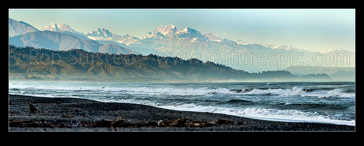 Image of Aoraki Mt Cook (3754m) and Mt Tasman (3497m) centre with Southern Alps Main Divide towering over Westland beach near Hokitika, at dawn. Ross at left. Panorama, Hokitika, Westland District, West Coast Region, New Zealand (NZ) stock photo image