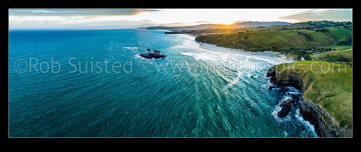 Image of Dunedin South Coast, looking along Smaills Beach to Tomahawk Beach, Lawyers Head and St Kilda behind. Bird Island at left. Aerial panorama at sunset, from near Maori Head, Otago Peninsula, Dunedin City District, Otago Region, New Zealand (NZ) stock photo image