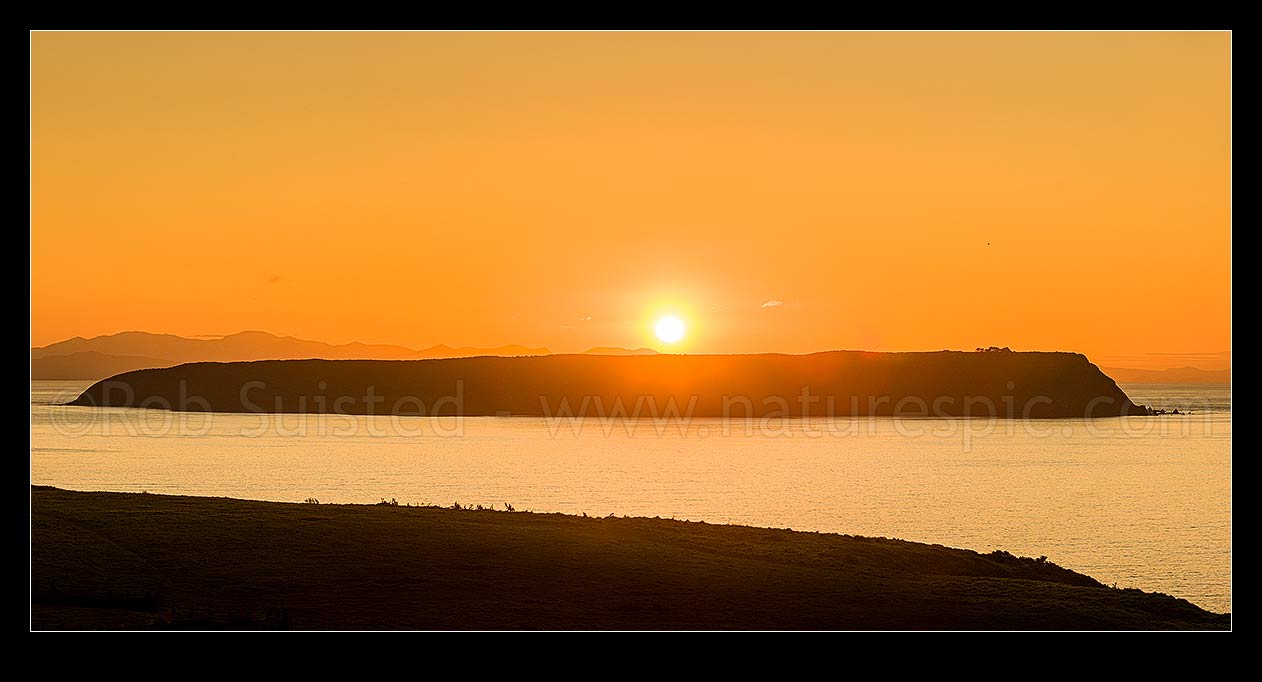 Image of Mana Island sunset on a calm evening. Seem from Whitireia Park. Cook Strait and South Island behind. Panorama, Titahi Bay, Porirua City District, Wellington Region, New Zealand (NZ) stock photo image