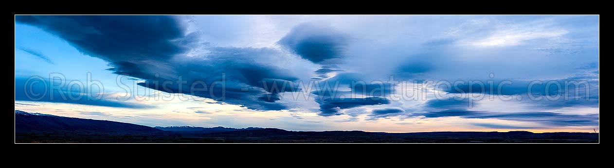 Image of Clouds over Central Otago. Moody dramatic lenticular clouds at dawn. Panorama, Middlemarch, Central Otago District, Otago Region, New Zealand (NZ) stock photo image