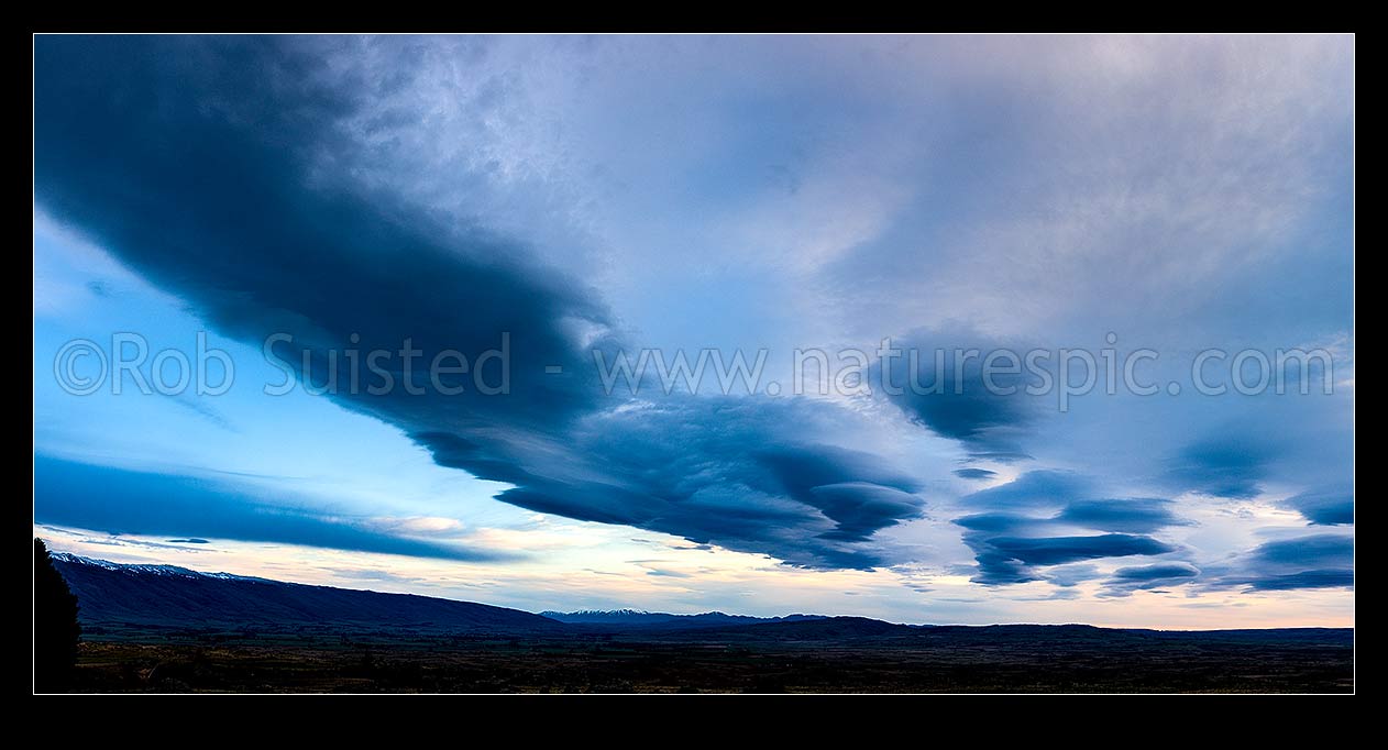 Image of Clouds over Central Otago. Moody dramatic lenticular clouds at dawn. Panorama, Middlemarch, Central Otago District, Otago Region, New Zealand (NZ) stock photo image