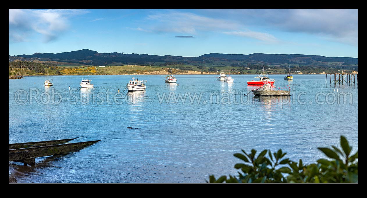 Image of Moeraki fishing fleet boats moored in Onekakara Bay on a calm morning. Panorama, Moeraki, Waitaki District, Canterbury Region, New Zealand (NZ) stock photo image