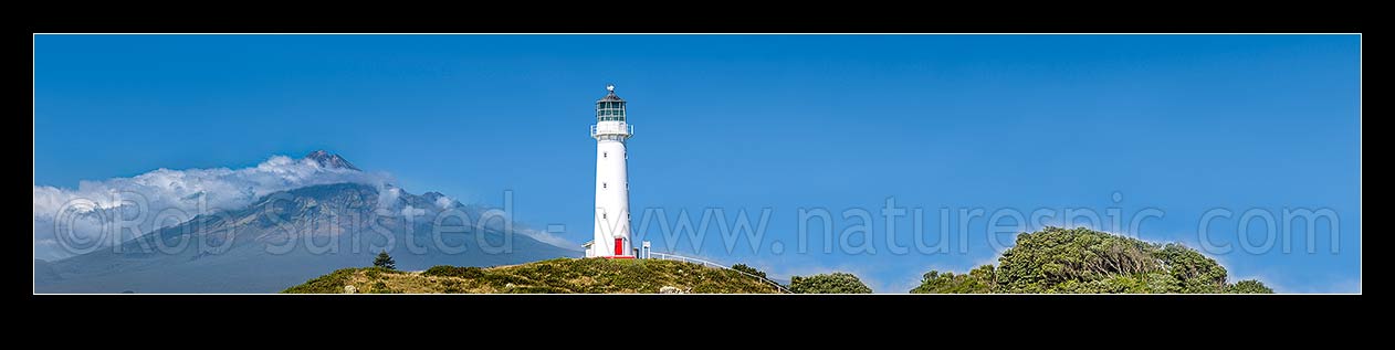 Image of Cape Egmont and lighthouse, with a cloud cloaked Mount Taranaki (2518m) behind. Panorama, Cape Egmont, South Taranaki District, Taranaki Region, New Zealand (NZ) stock photo image