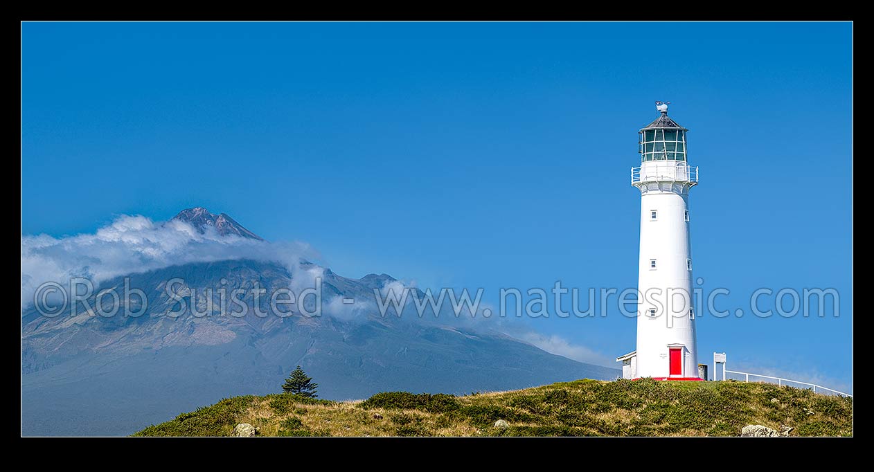 Image of Cape Egmont and lighthouse, with a cloud cloaked Mount Taranaki (2518m) behind. Panorama, Cape Egmont, South Taranaki District, Taranaki Region, New Zealand (NZ) stock photo image