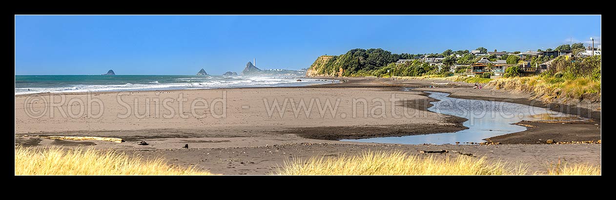 Image of Oakura Beach front and Waimoku Stream. Nga Motu Sugar Loaf Islands, Paritutu Rock (154m) and distinctive power station chimney behind. Panorama, Oakura, New Plymouth District, Taranaki Region, New Zealand (NZ) stock photo image