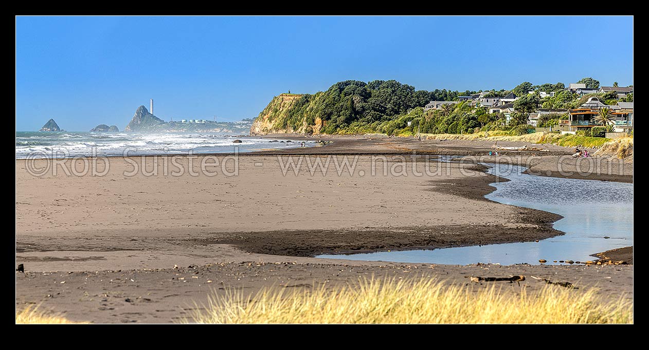 Image of Oakura Beach front and Waimoku Stream. Nga Motu Sugar Loaf Islands, Paritutu Rock (154m) and distinctive power station chimney behind. Panorama, Oakura, New Plymouth District, Taranaki Region, New Zealand (NZ) stock photo image