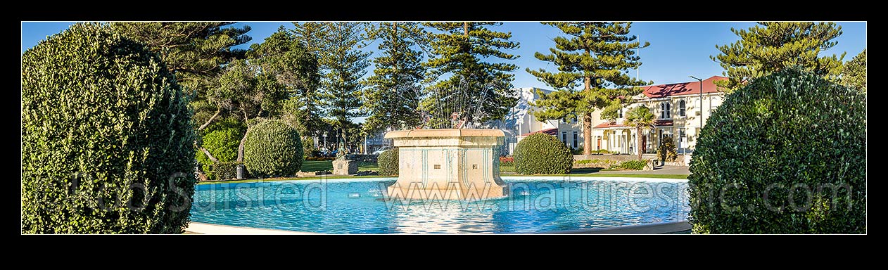 Image of Napier's iconic Tom Parker Art Deco fountain 1936, in Napier's warterfront gardens and marine parade. Pania of the Reef statue behind. Panorama, Napier, Napier City District, Hawke's Bay Region, New Zealand (NZ) stock photo image