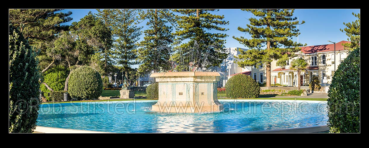 Image of Napier's iconic Tom Parker Art Deco fountain 1936, in Napier's warterfront gardens and marine parade. Pania of the Reef statue behind. Panorama, Napier, Napier City District, Hawke's Bay Region, New Zealand (NZ) stock photo image