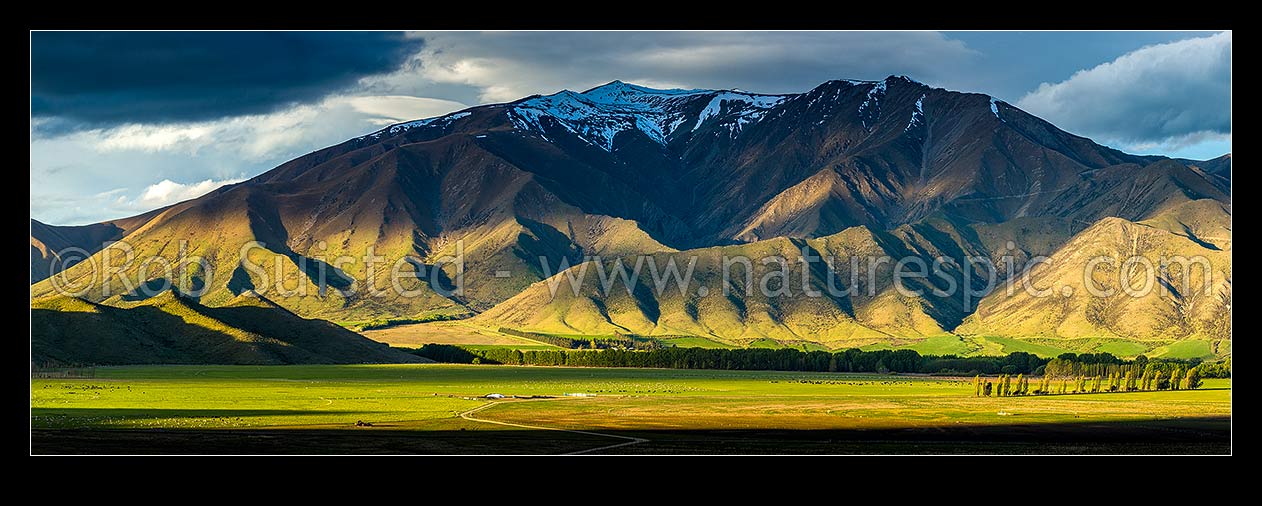 Image of Moody farmland and high country of the Benmore Range and Totara Peak (1822m above). Including dairy farmland and pivot irrigator. Panorama, Omarama, MacKenzie District, Canterbury Region, New Zealand (NZ) stock photo image