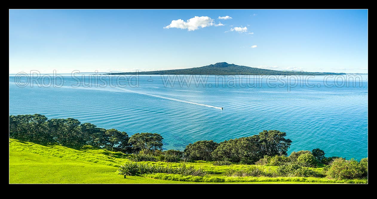 Image of Rangitoto Island Scenic Reserve in the Hauraki Gulf, seen from North Head Historic Reserve, with passing recreational power boat. Panorama, Cheltenham, Auckland City District, Auckland Region, New Zealand (NZ) stock photo image