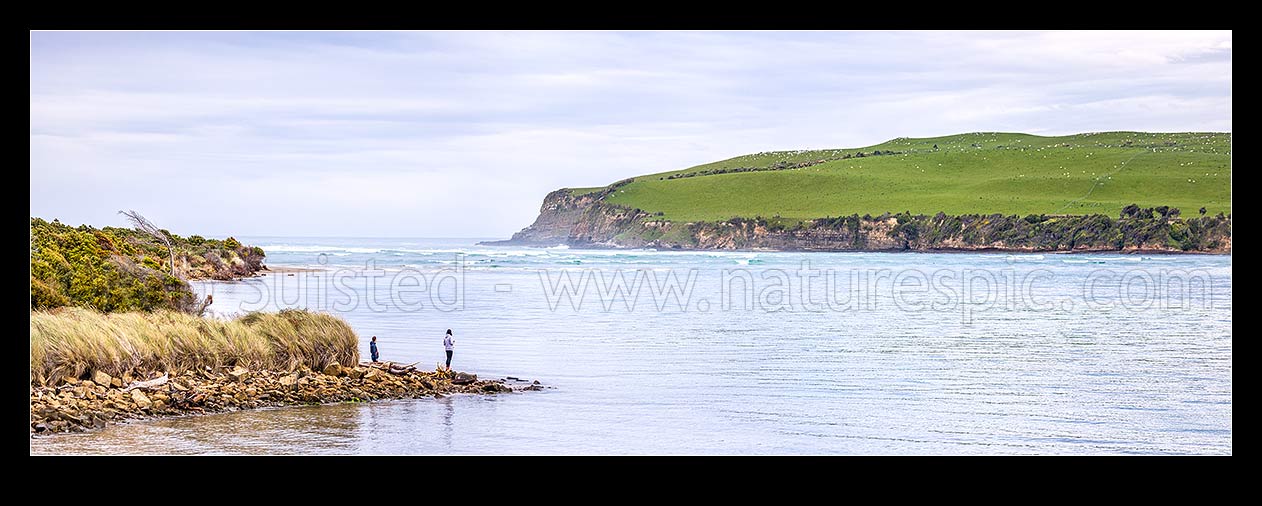 Image of Catlins River mouth at Surat Bay New Haven, with Catlins Head beyond, at high tide. Visitors enjoying the sight. Panorama, Catlins, Clutha District, Otago Region, New Zealand (NZ) stock photo image