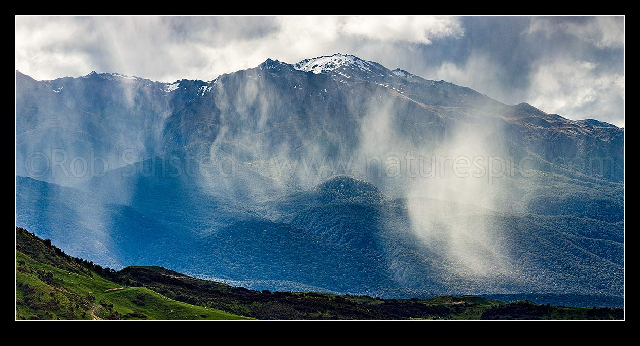 Image of Mount Titiroa (1715m) with spring snow showers falling in the Waiau River valley and slopes. Blackmount foreground. Panorama, Fiordland National Park, Southland District, Southland Region, New Zealand (NZ) stock photo image