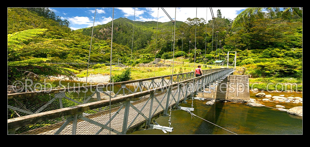 Image of Historic Karangahake Goldfields ruins and walking tracks, with visitors crossing the Ohinemuri lower Waitawheta Gorge bridge. Panorama, Karangahake, Hauraki District, Waikato Region, New Zealand (NZ) stock photo image