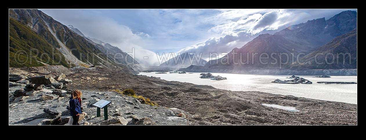 Image of Tourist visitors at lookout above the Tasman Glacier morraine and terminal lake. Aoraki Mount Cook Range left, Burnett Range right. Tasman Valley. Panorama, Mount Cook National Park, MacKenzie District, Canterbury Region, New Zealand (NZ) stock photo image