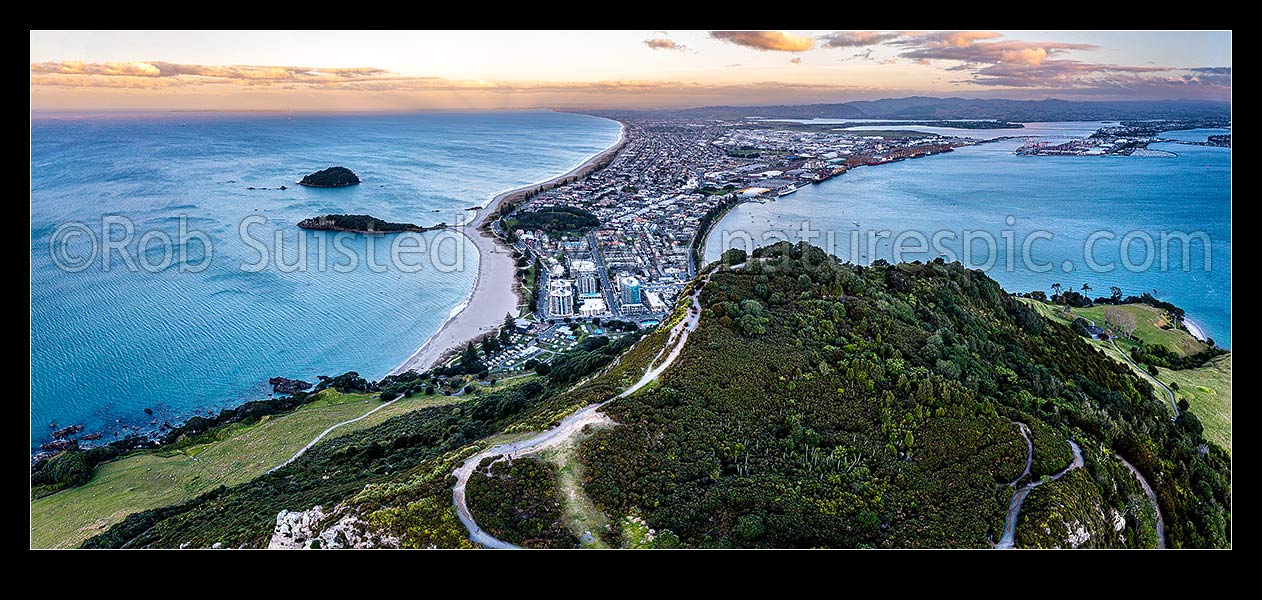 Image of Mt Maunganui summit Mauao at the Tauranga Harbour Entrance. 231m high lava dome. Mt Maunganui Beach left, Tauranga Harbour right. Aerial view at dusk, Mount Maunganui, Tauranga District, Bay of Plenty Region, New Zealand (NZ) stock photo image